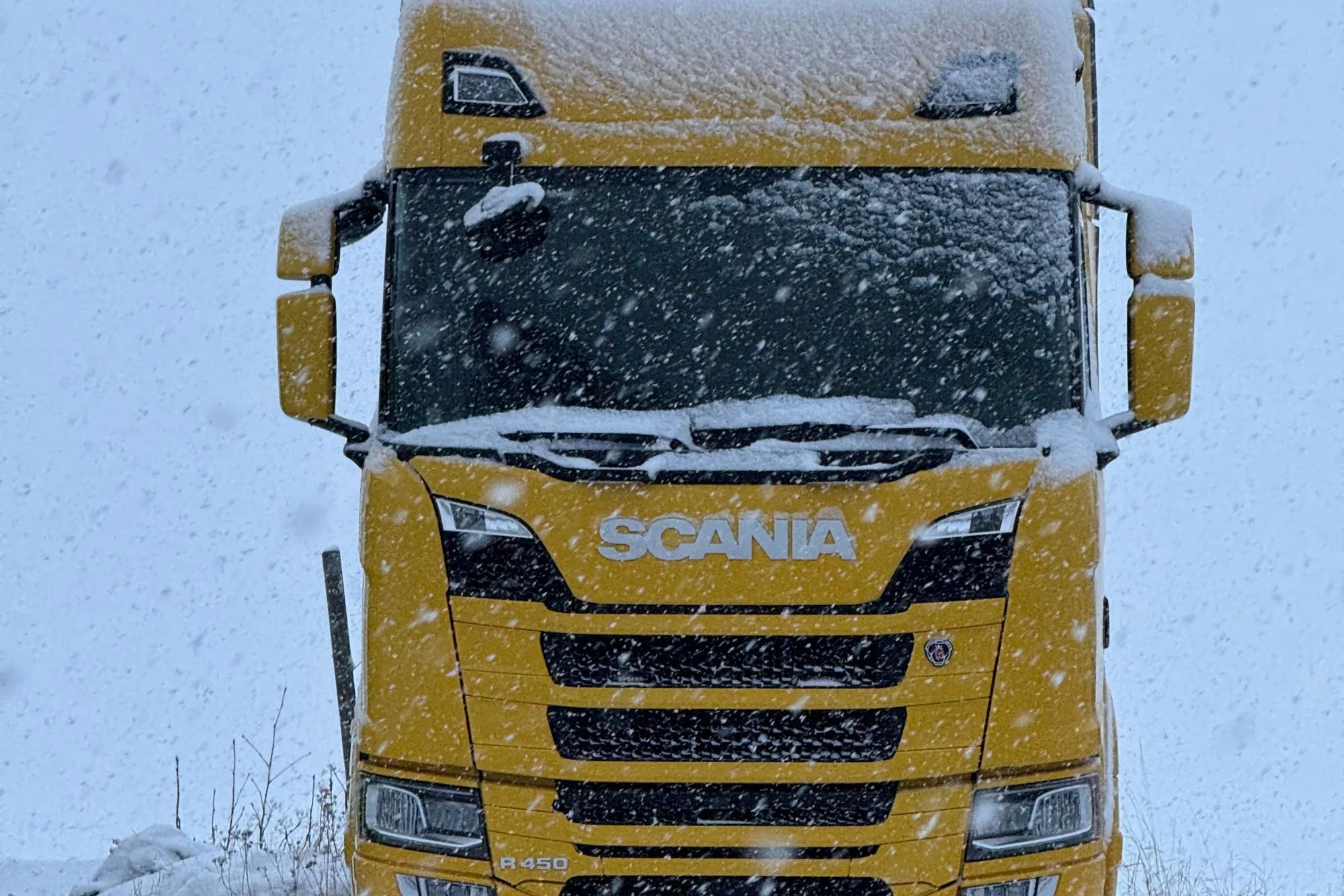 Scania-lastbil parkerad i snöfall